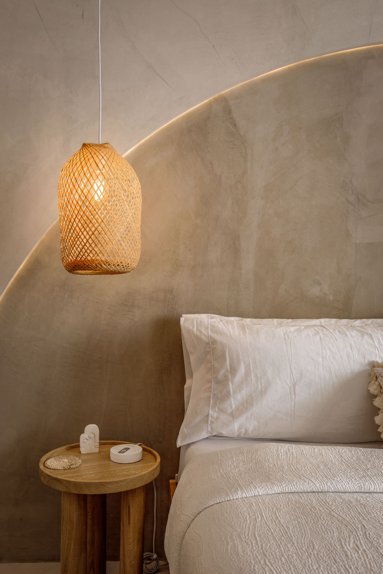 Chambre préparée avec suspension en rotin et linge de lit clair